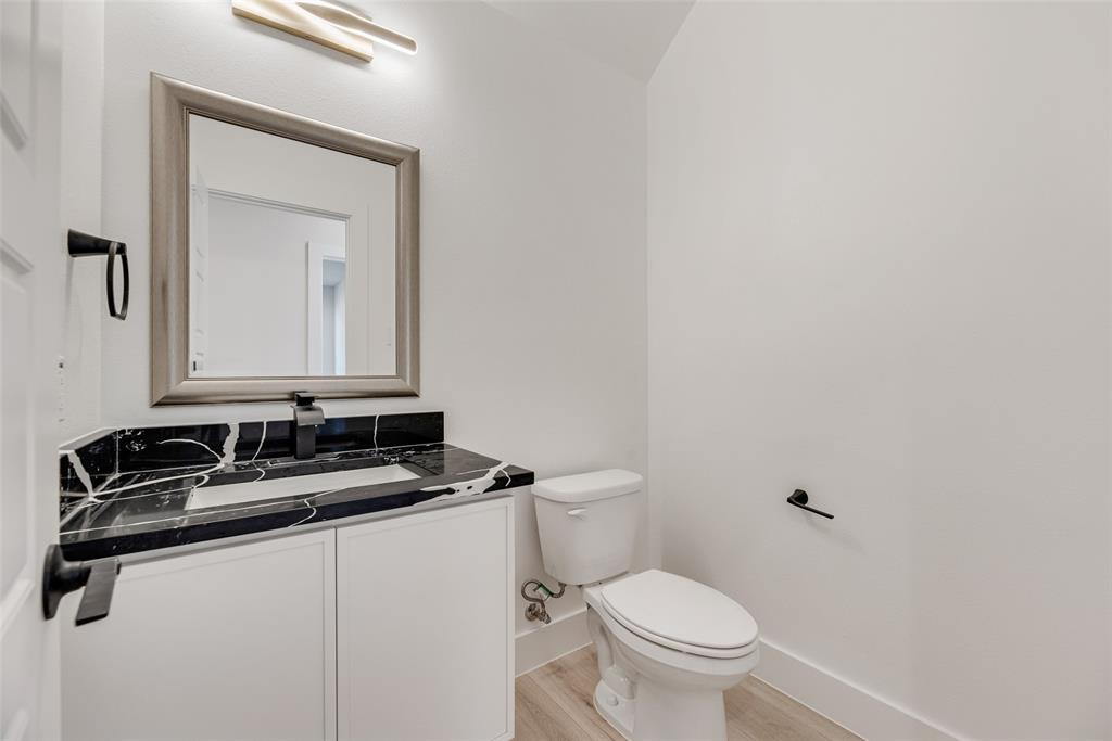 6046 Plum Dale Road Dallas, TX 75241 - Photo 25 of 27 a bathroom with a granite countertop sink and a toilet