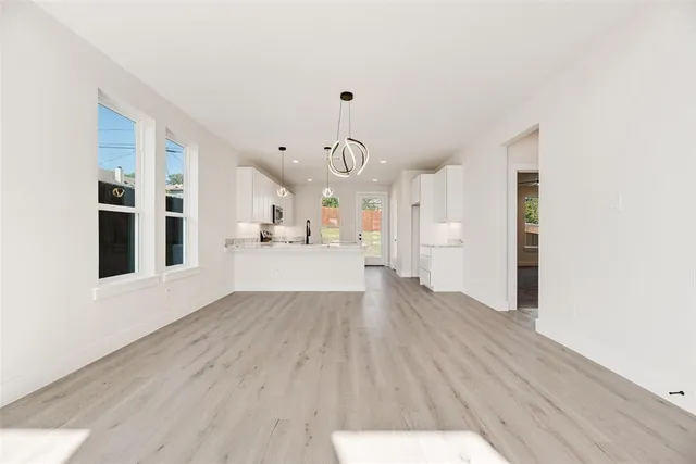 a view of a kitchen with wooden floor and windows