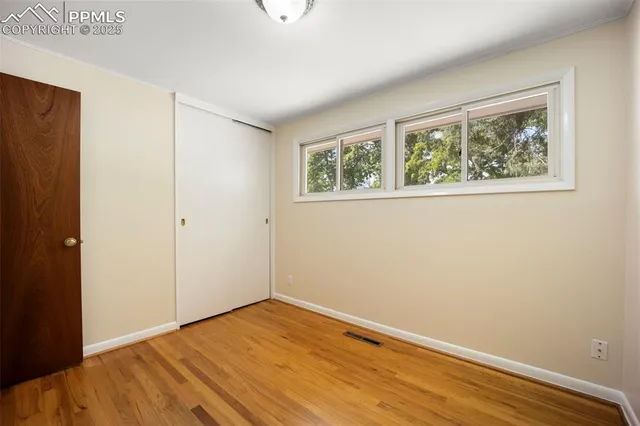 an empty room with wooden floor and window