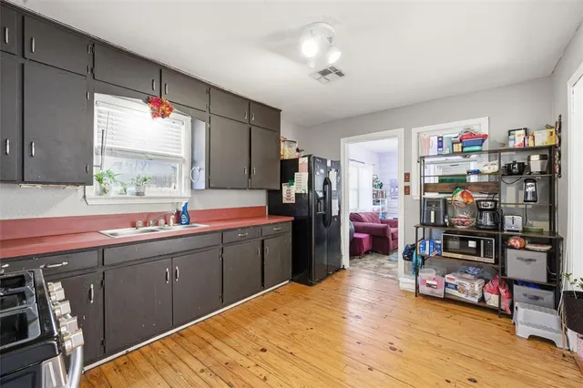 a kitchen that has a lot of cabinets a sink and a bed