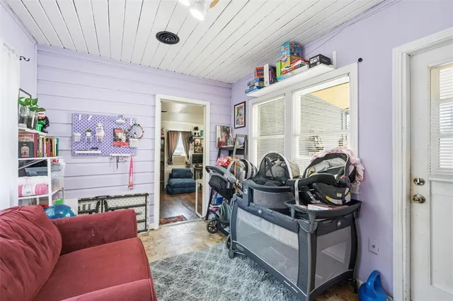 a living room with furniture a window and gym equipment