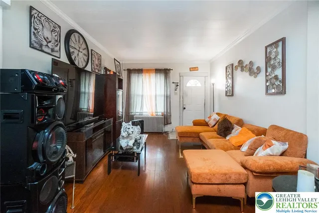 a living room with furniture a flat screen tv and a wall clock