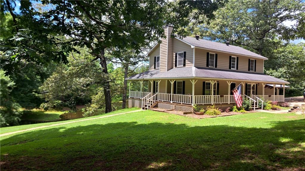 a view of a house with a yard and sitting area