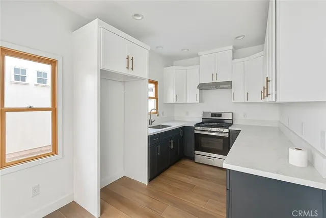 a kitchen with stainless steel appliances granite countertop a stove a sink and a refrigerator