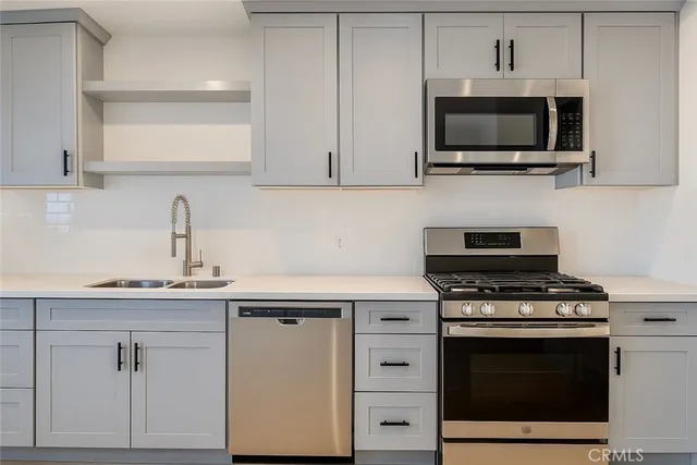 a kitchen with cabinets stainless steel appliances and a sink