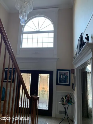 a view of a room with wooden floor and chandelier