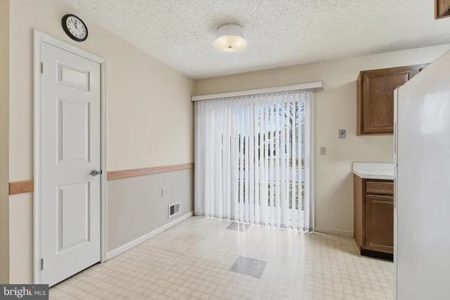 a kitchen with kitchen island wooden cabinets and refrigerator