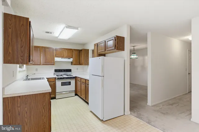a kitchen with a refrigerator sink and cabinets