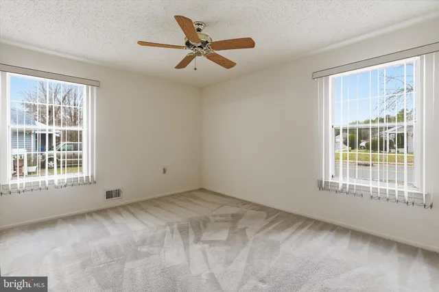an empty room with closet and a ceiling fan
