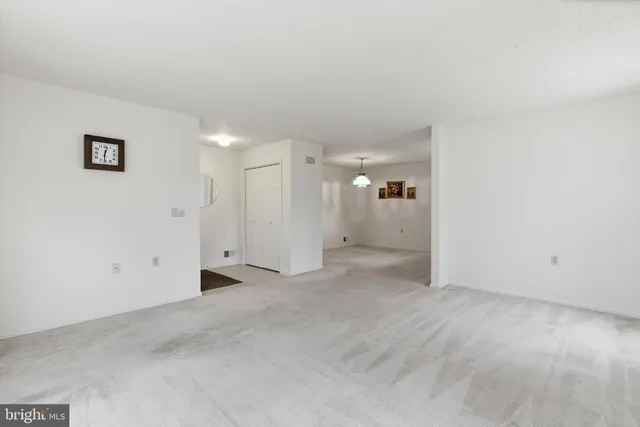 en empty room with window and chandelier fan