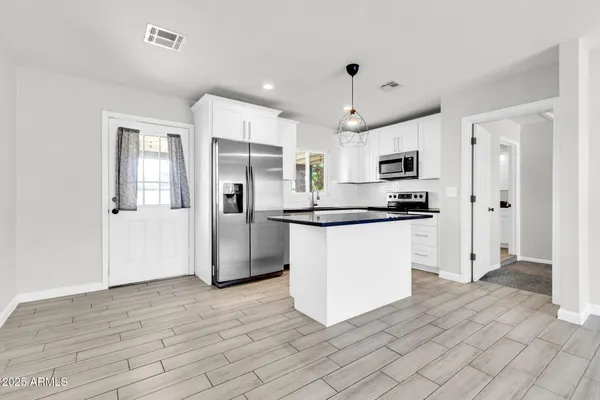 a kitchen with stainless steel appliances a refrigerator sink and microwave