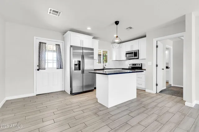 a kitchen with stainless steel appliances a refrigerator sink and microwave