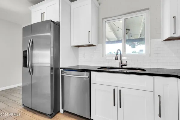a kitchen with stainless steel appliances granite countertop a refrigerator and a sink