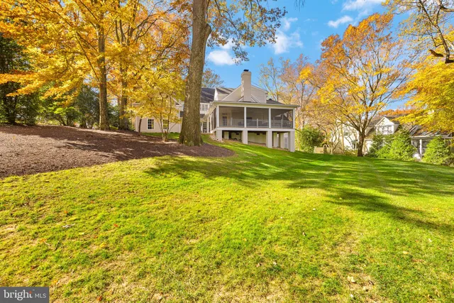 a view of a house with a big yard and large trees