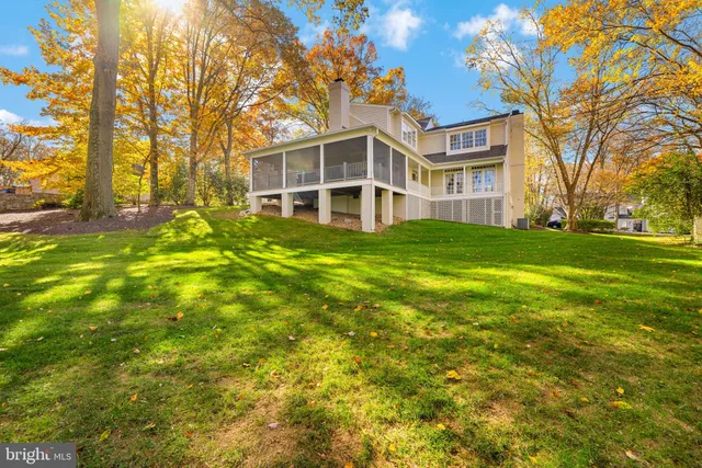 a view of a big yard with large trees and wooden fence