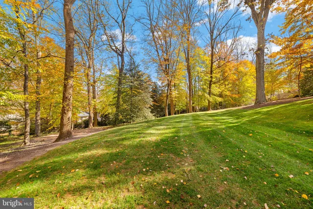 a view of a large pool with lawn chairs under an umbrella
