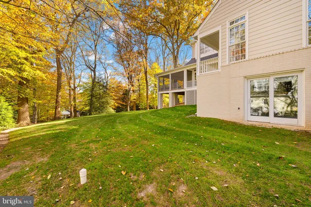 a view of a house with a big yard and large trees