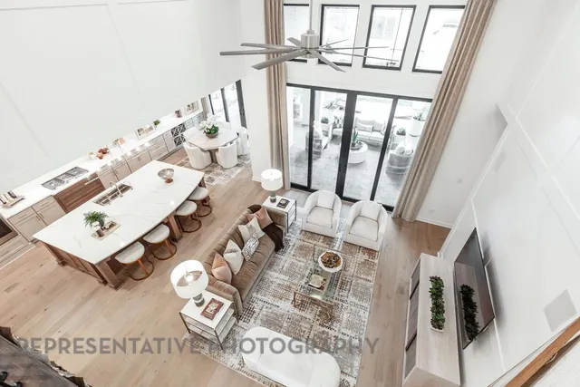 a living room with furniture kitchen view and a large window