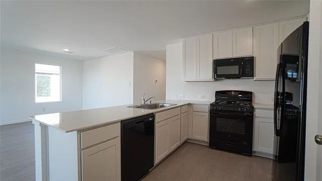 a kitchen with a sink and steel appliances