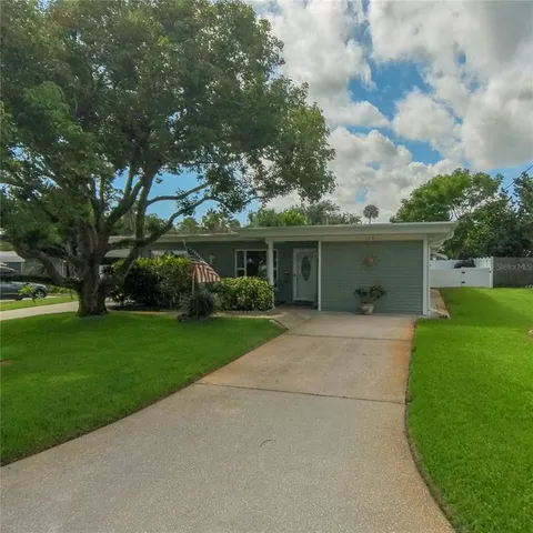 front view of house with a yard and potted plants