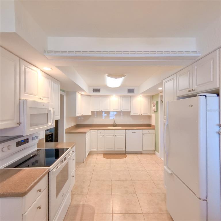 120 Rhode Island Street Edgewater, FL 32132 - Photo 8 of 28 a kitchen with stainless steel appliances a refrigerator sink and cabinets