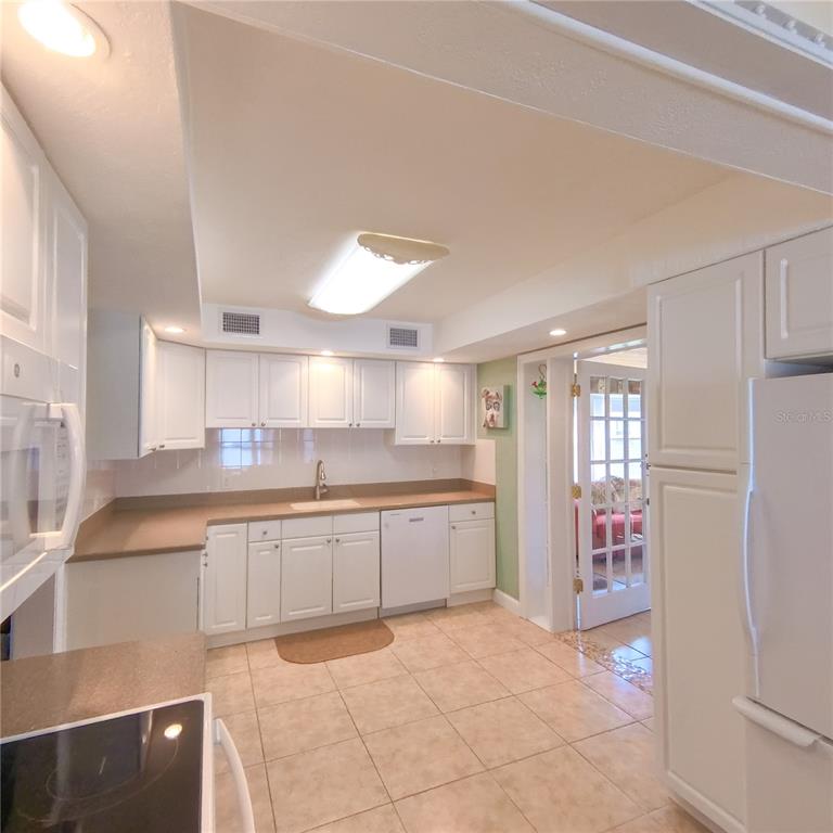 120 Rhode Island Street Edgewater, FL 32132 - Photo 9 of 28 a large kitchen with kitchen island a sink a stove a refrigerator and cabinets
