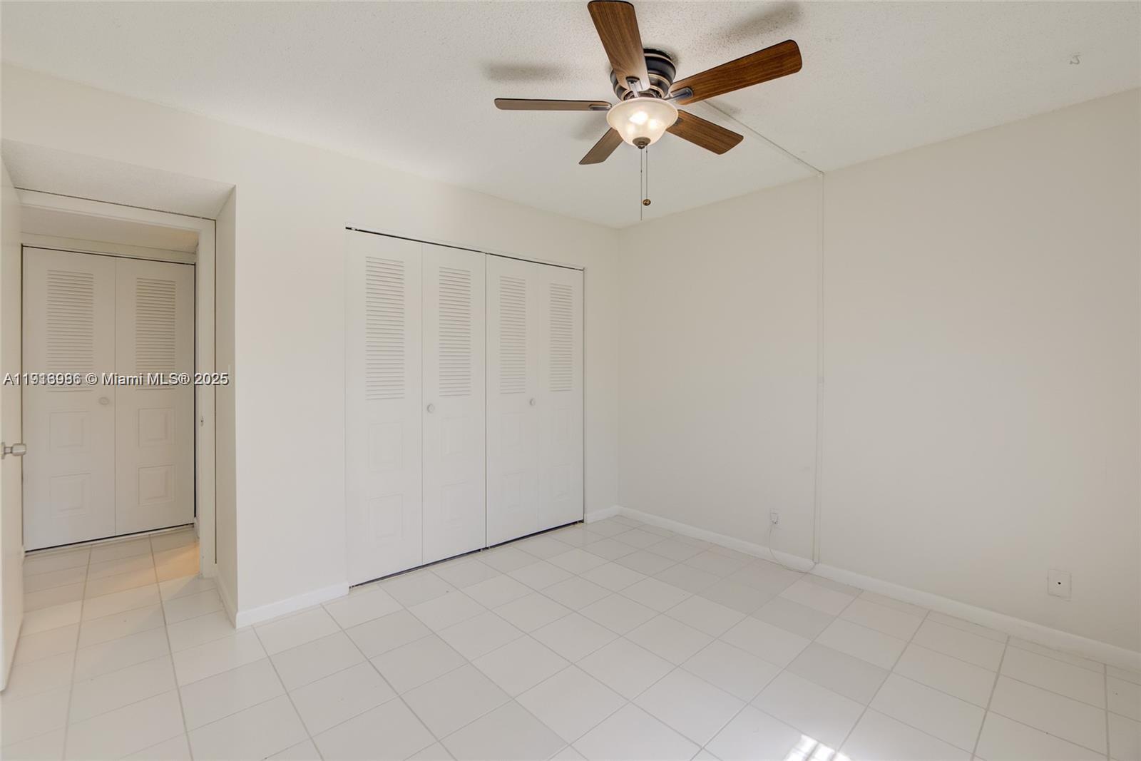 31 Cortez Way, Unit 543 Davie, FL 33324 - Photo 23 of 36 an empty room with a ceiling fan and a fan