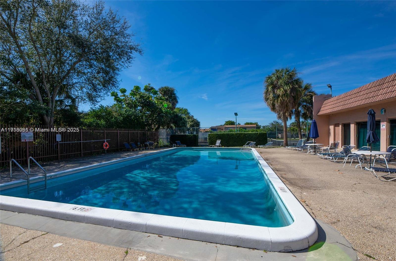 31 Cortez Way, Unit 543 Davie, FL 33324 - Photo 31 of 36 a swimming pool with outdoor seating and yard