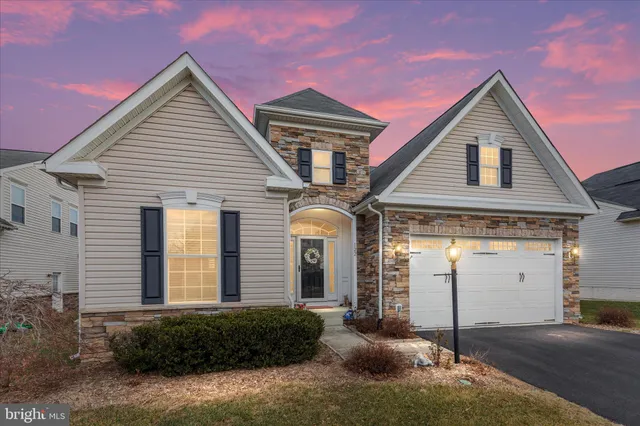 a dining room with furniture potted plants and wooden floor
