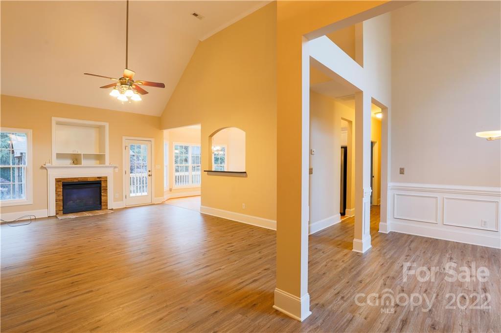 142 Princess Loop Troutman, NC 28166 - Photo 14 of 22 a view of a livingroom with wooden floor a ceiling fan and windows