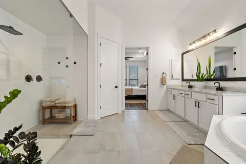 a large white bathroom with a granite countertop sink mirror and bathtub
