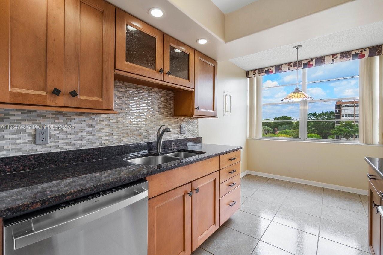 a kitchen with stainless steel appliances granite countertop a sink and a wooden cabinets