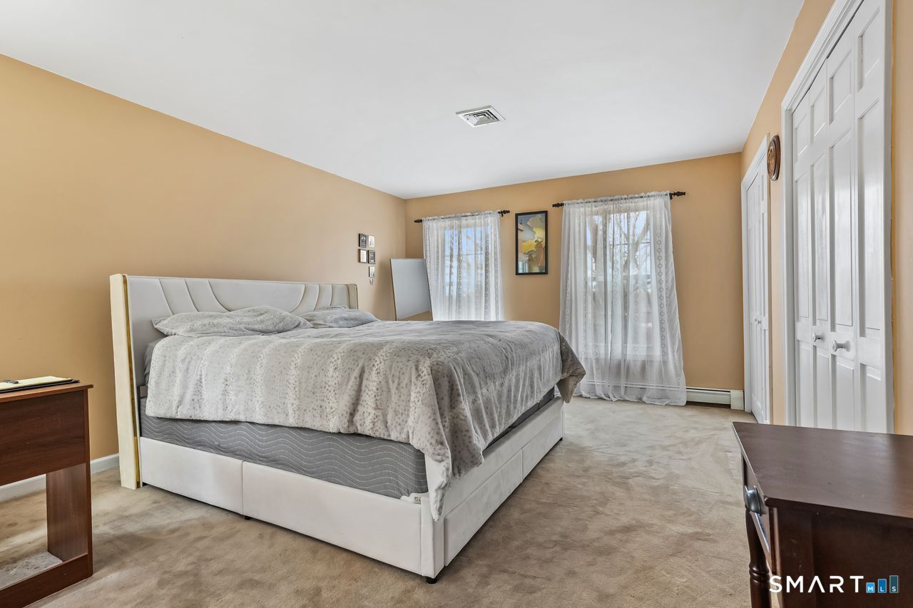 46 Little Brook Lane Newtown, CT 06470 - Photo 15 of 27 a bedroom with a bed lamp and a large window