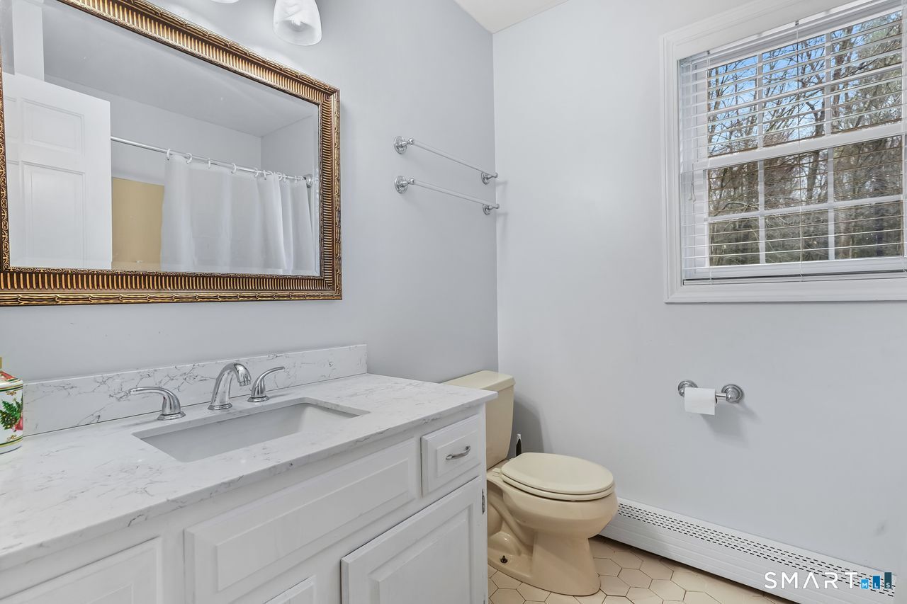 46 Little Brook Lane Newtown, CT 06470 - Photo 21 of 27 a bathroom with a sink a toilet and a mirror