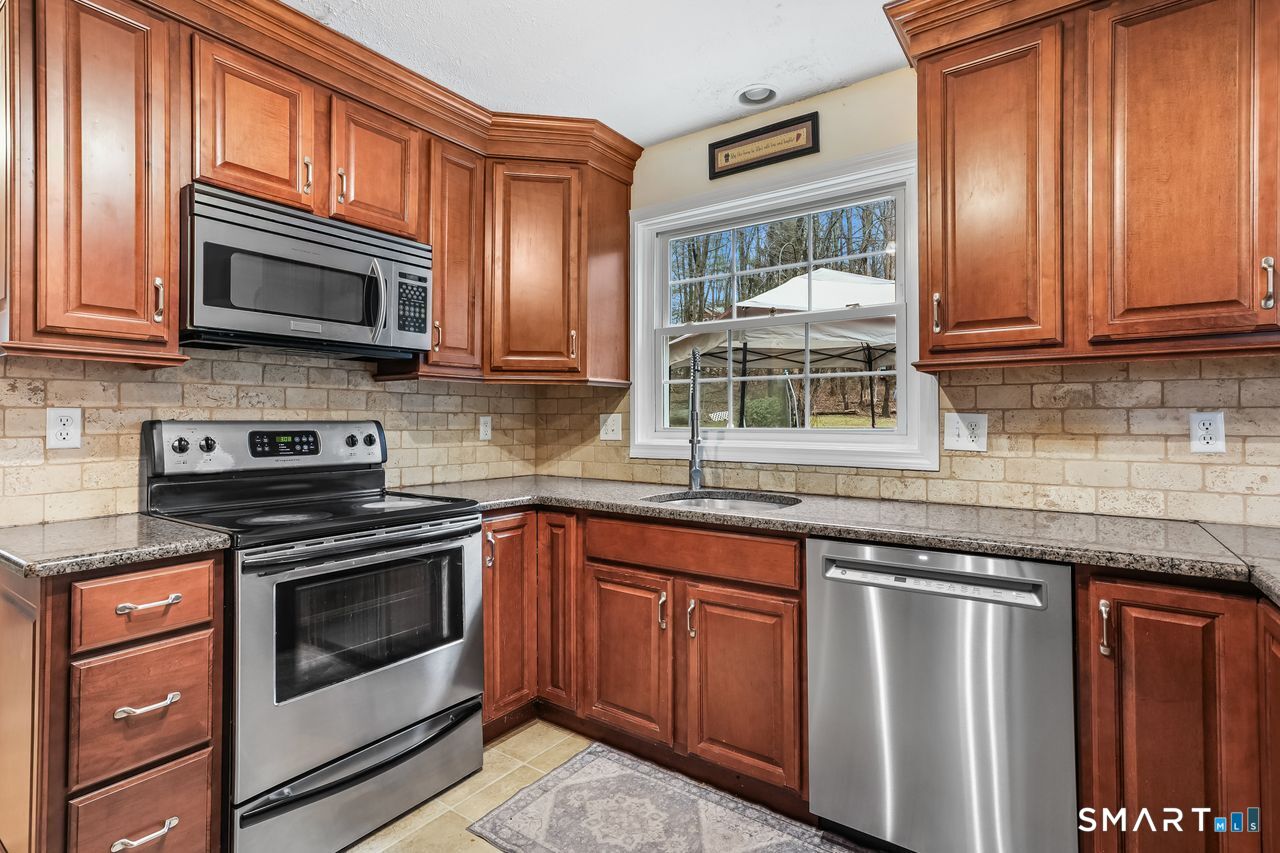 46 Little Brook Lane Newtown, CT 06470 - Photo 8 of 27 a kitchen with stainless steel appliances granite countertop a stove microwave and cabinets