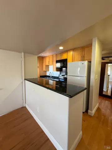 a kitchen with refrigerator and cabinets