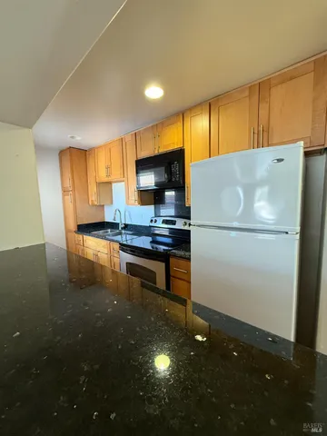 a kitchen with stainless steel appliances a refrigerator and a stove top oven