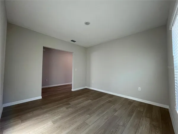 a view of an empty room with wooden floor