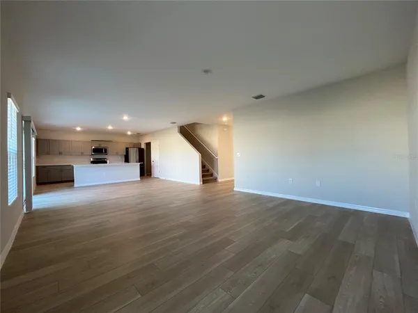 a view of empty room with a kitchen