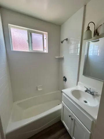 a bathroom with a tub sink and mirror