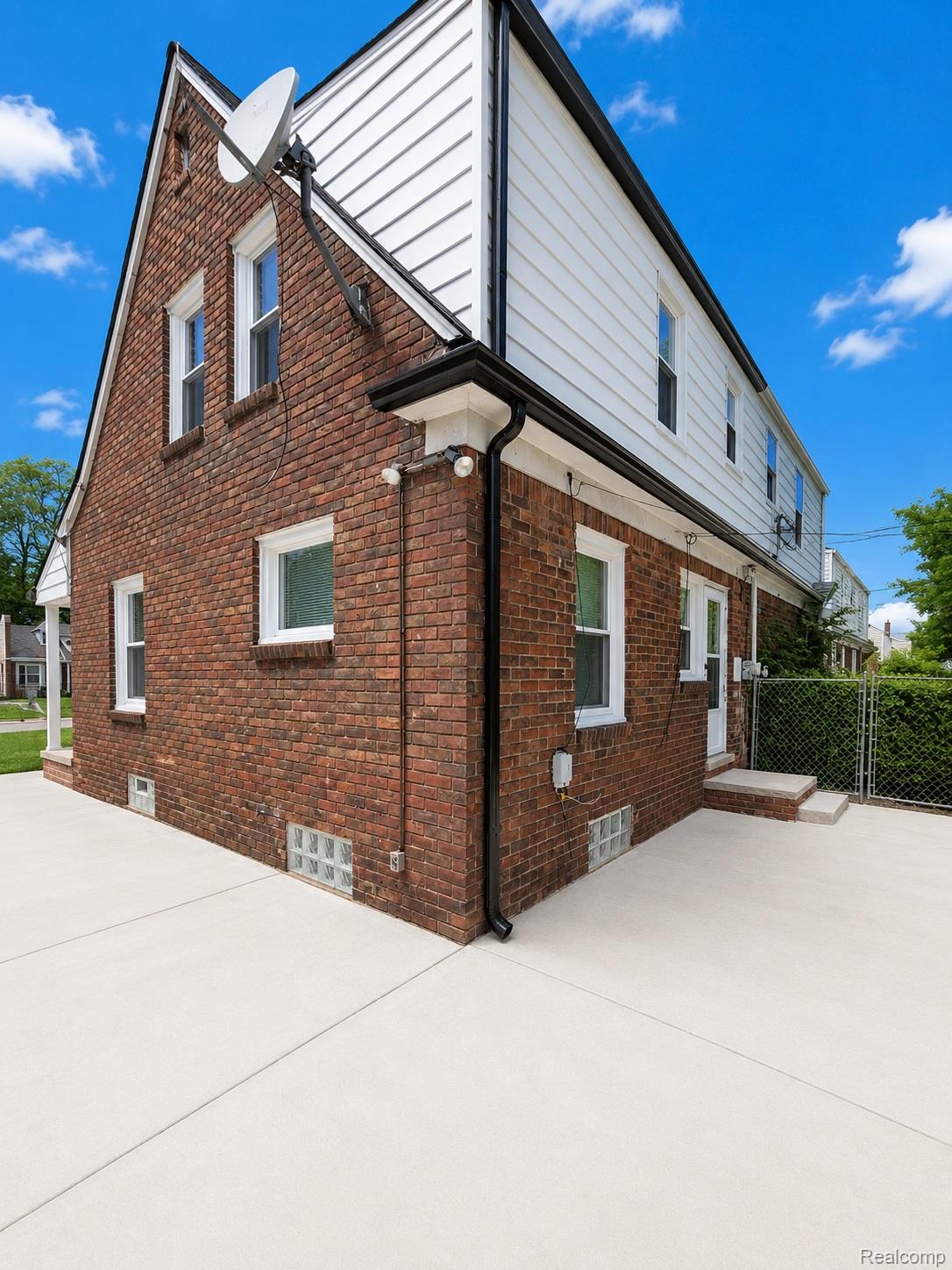 20024 Meyers Road Detroit, MI 48235 - Photo 14 of 16 Brick and siding exterior featuring white trim and multiple windows