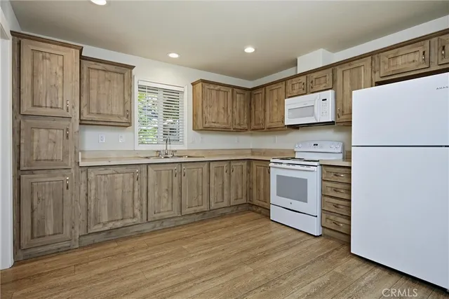 a kitchen with white cabinets and white appliances