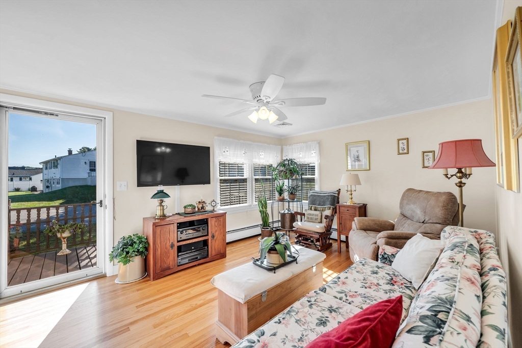 34 Adams Street Ludlow, MA 01056 - Photo 21 of 42 a living room with furniture a flat screen tv and a floor to ceiling window