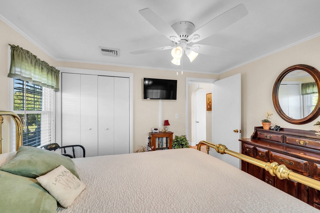 34 Adams Street Ludlow, MA 01056 - Photo 23 of 42 a bedroom with a bed a mirror on the dresser and a chandelier
