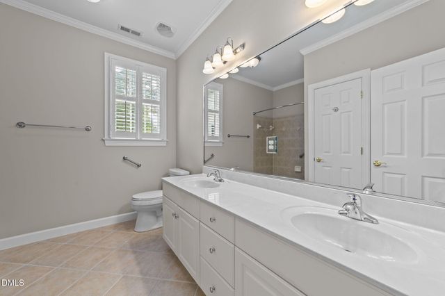 a spacious bathroom with a double vanity sink a large mirror and a bathtub