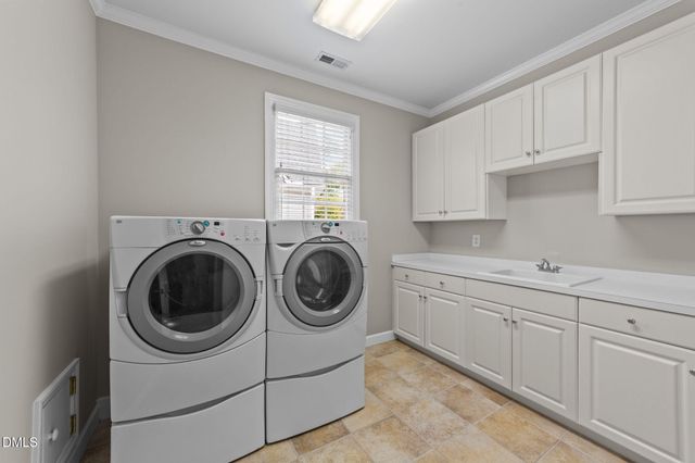 a utility room with sink dryer and washer