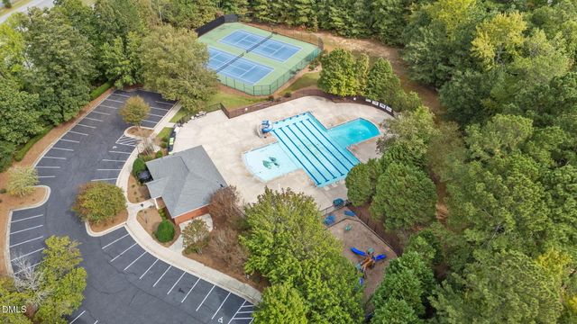 aerial view of a house with a yard and green space