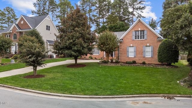 a front view of a house with a yard and trees