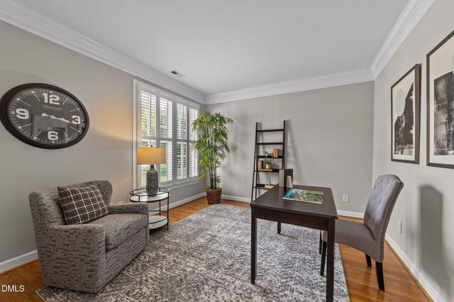 a dining room with wooden floor a chandelier a wooden table and chairs