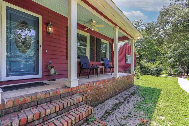 a view of a house with backyard porch and sitting area